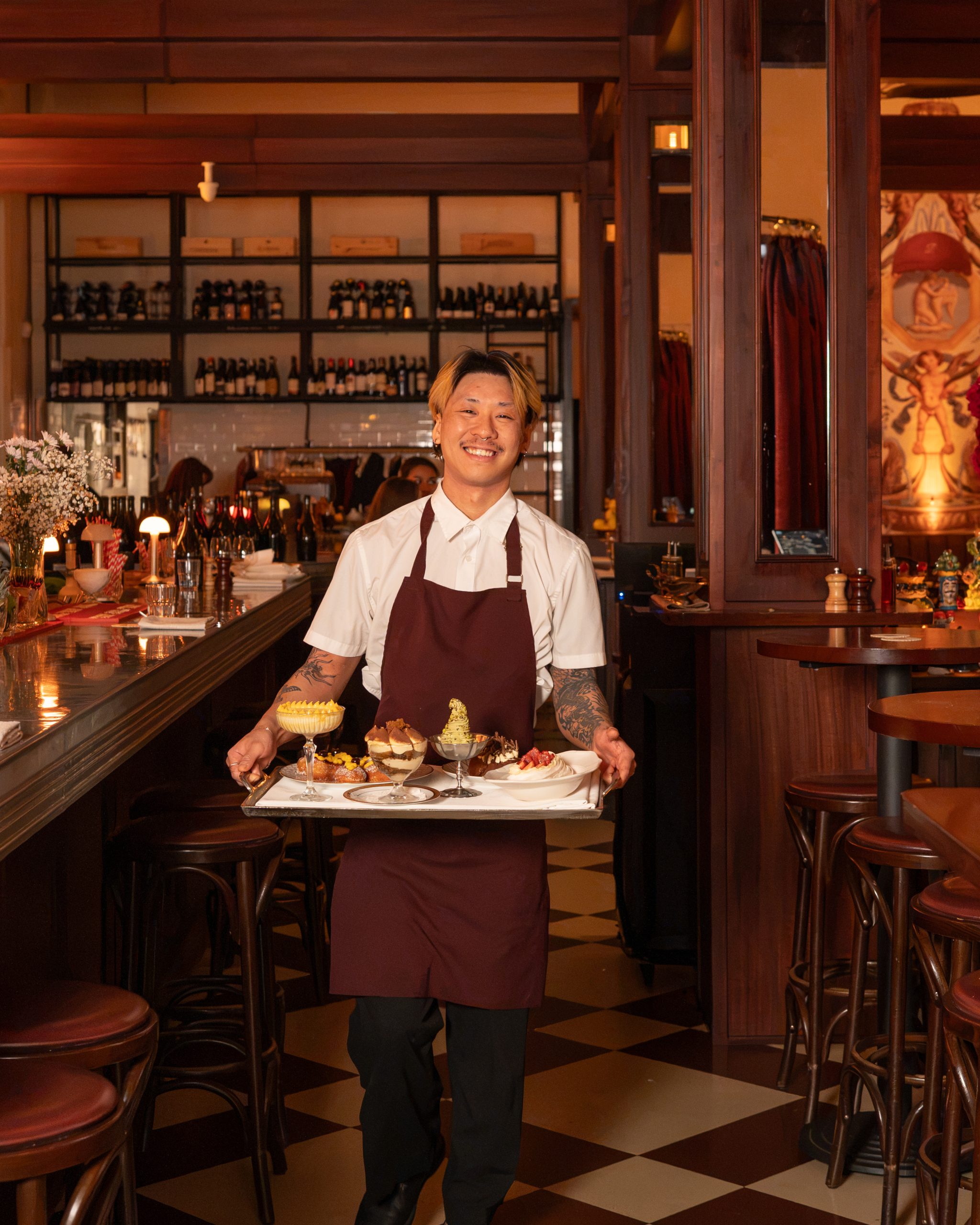 A waiter carrying a tray of desserts through Pepe's Main Dining Room